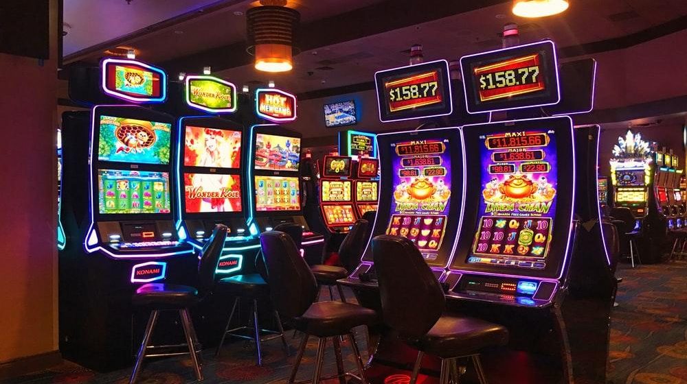 Various slot machines with chairs in a casino