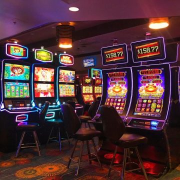 Various slot machines with chairs in a casino