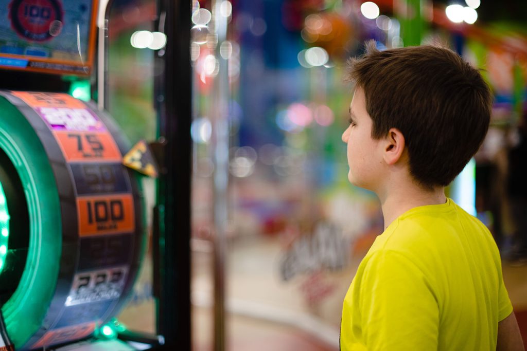  Boy staring at a slot machine game.
