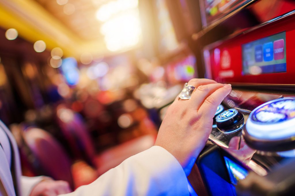 Woman playing on a slot machine.
