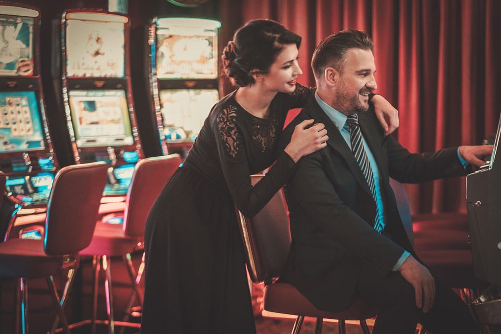 A happy couple enjoying slots at a casino
