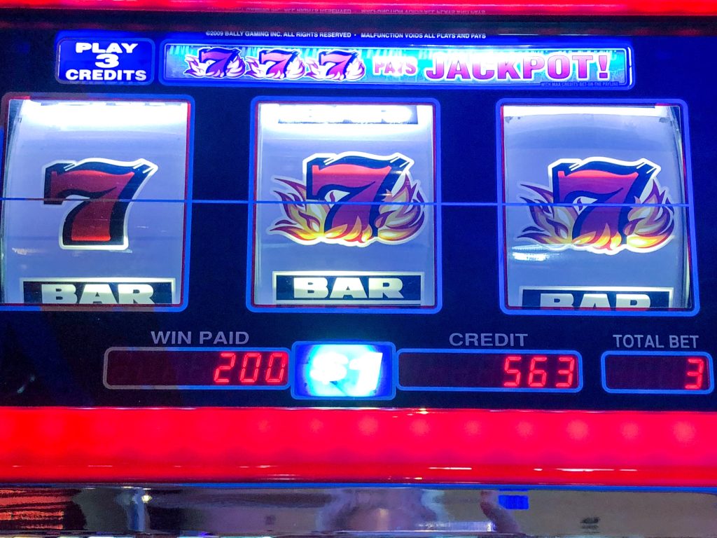A slot machine with winning triple 7s jackpot
